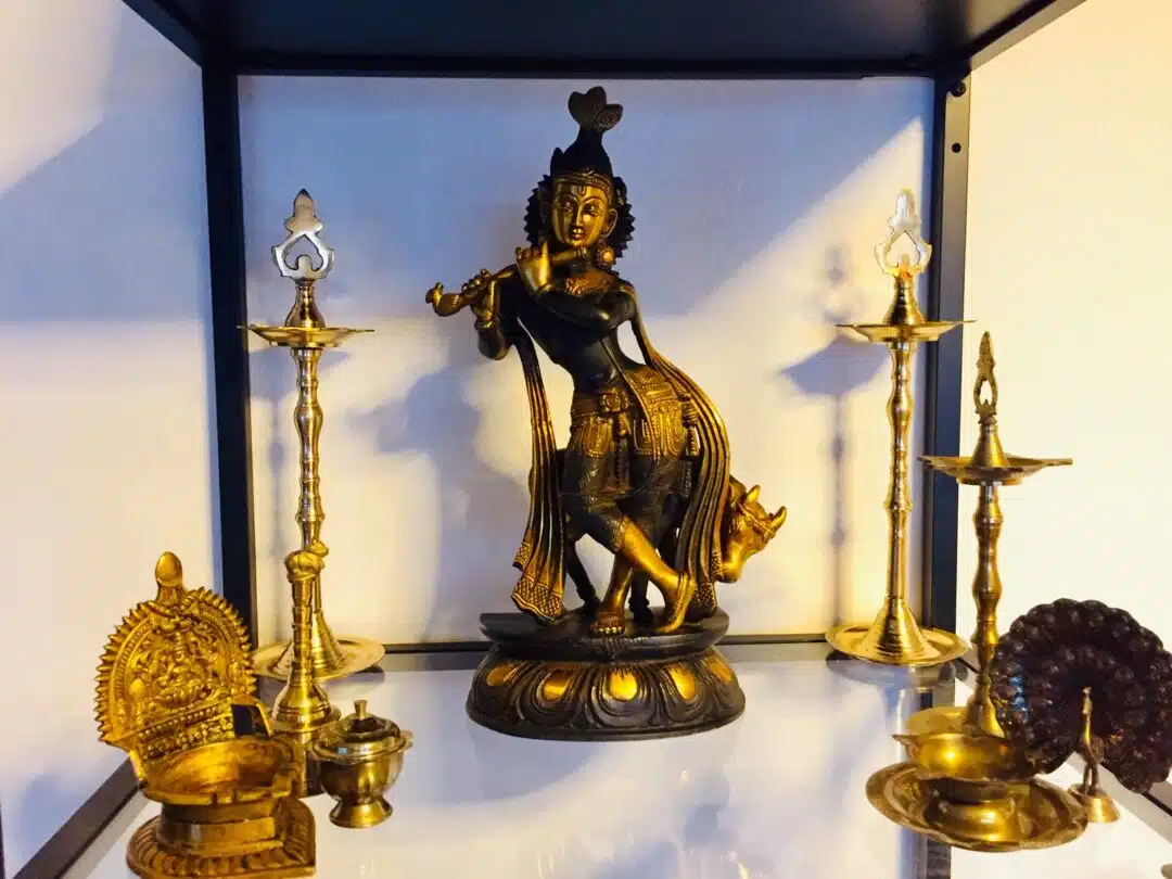 Krishna Statue braungold im Schrank stehend mit anderen schönen Dingen